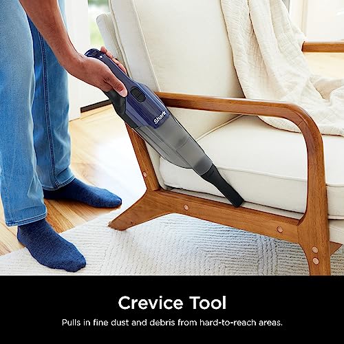 Handheld vacuum being used on car interior