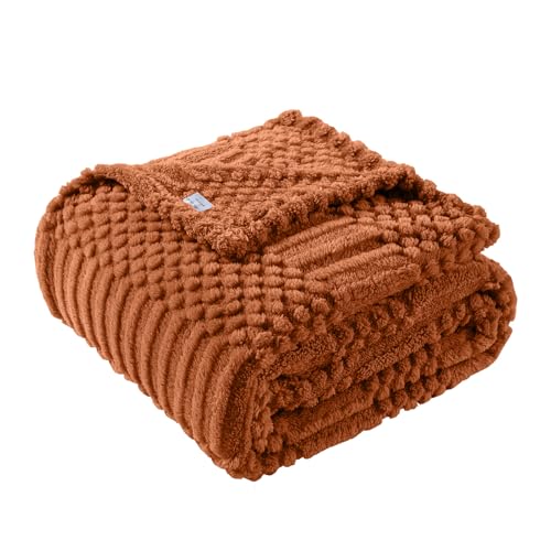 Lussena Rust Throw Blanket draped on a couch