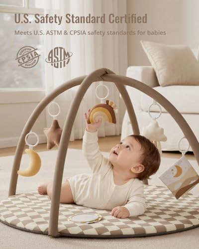 Newborn baby playing on activity mat