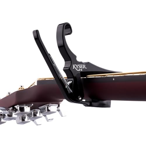 Kyser capo mounted on acoustic guitar headstock